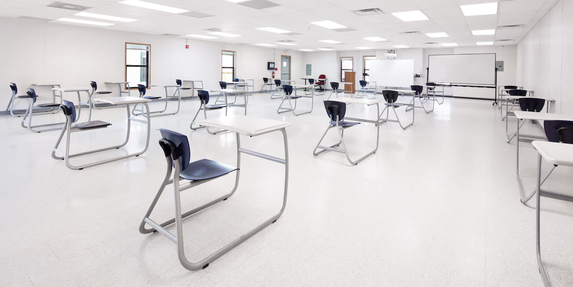 An empty classroom furnished with desks and chairs