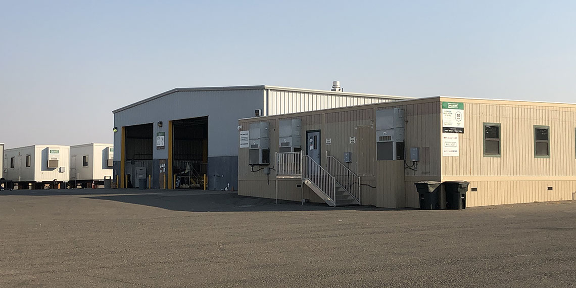 a warehouse inbetween mobile offices and modular buildings at the WillScot Sacramento West, CA lot